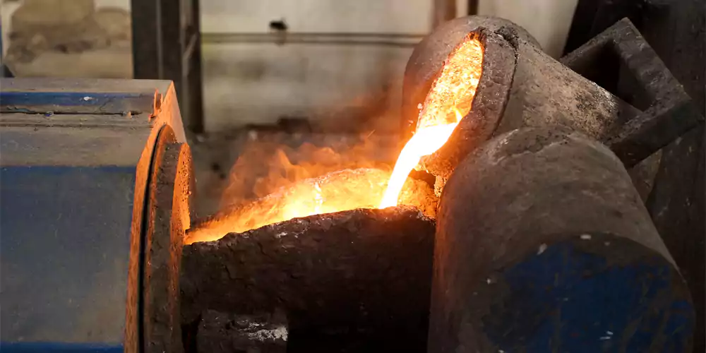 A centrifugal casting machine in operation, with molten metal being poured into a spinning mold